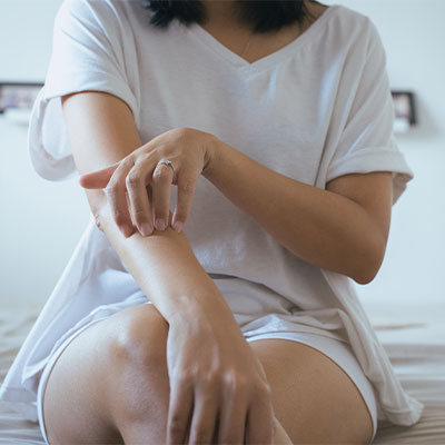 Dry skin on the lower arm causing a woman to itch.