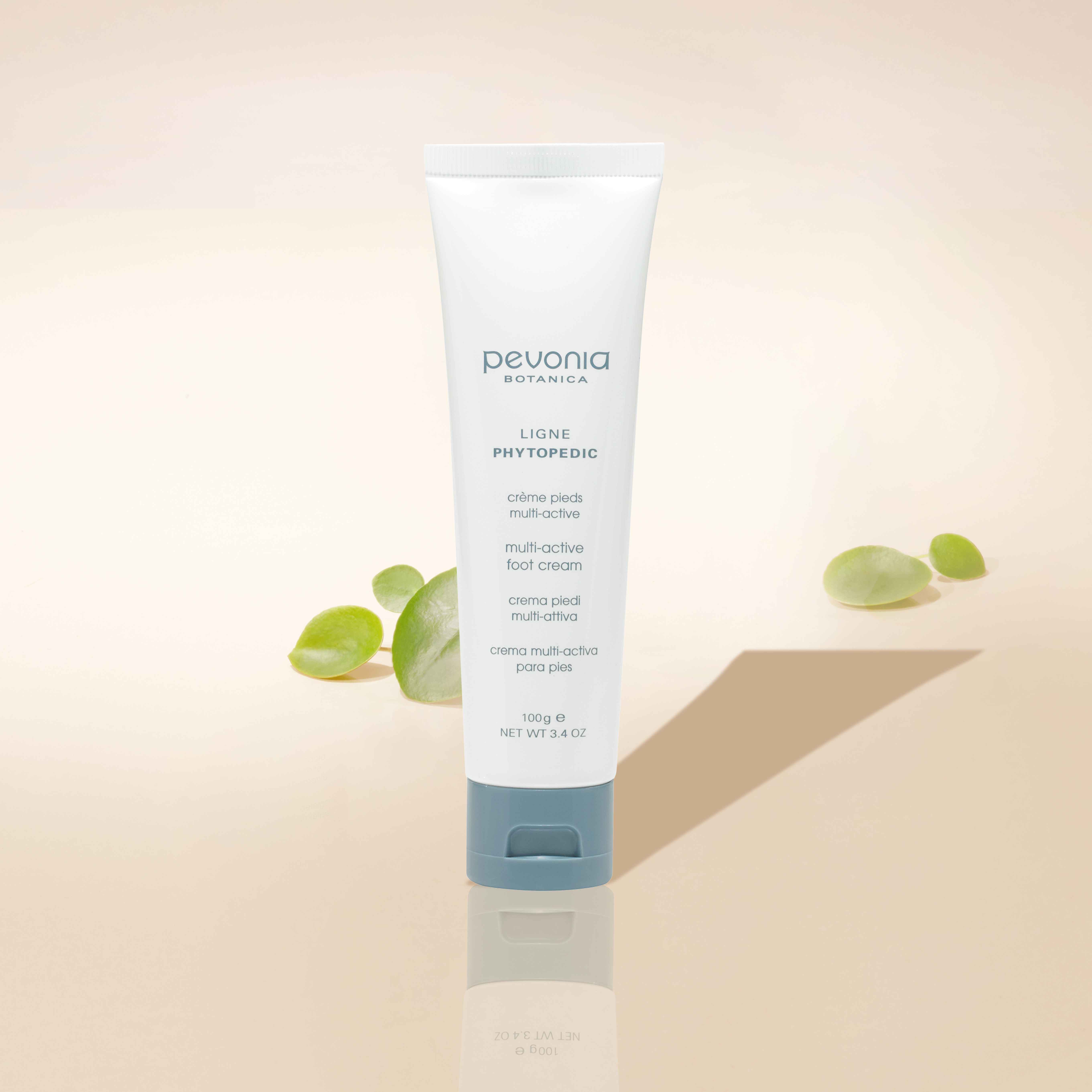 Multi-Active Foot Cream on a light background, with small green leaves.