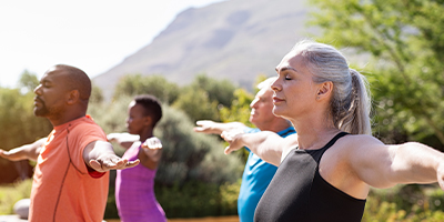 A friend group during an outdoor yoga class in the afternoon.