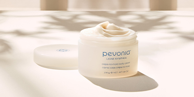 Pevonia's Crepe-No-More Body Cream with its cap off by a window, with natural light and shadows everywhere.