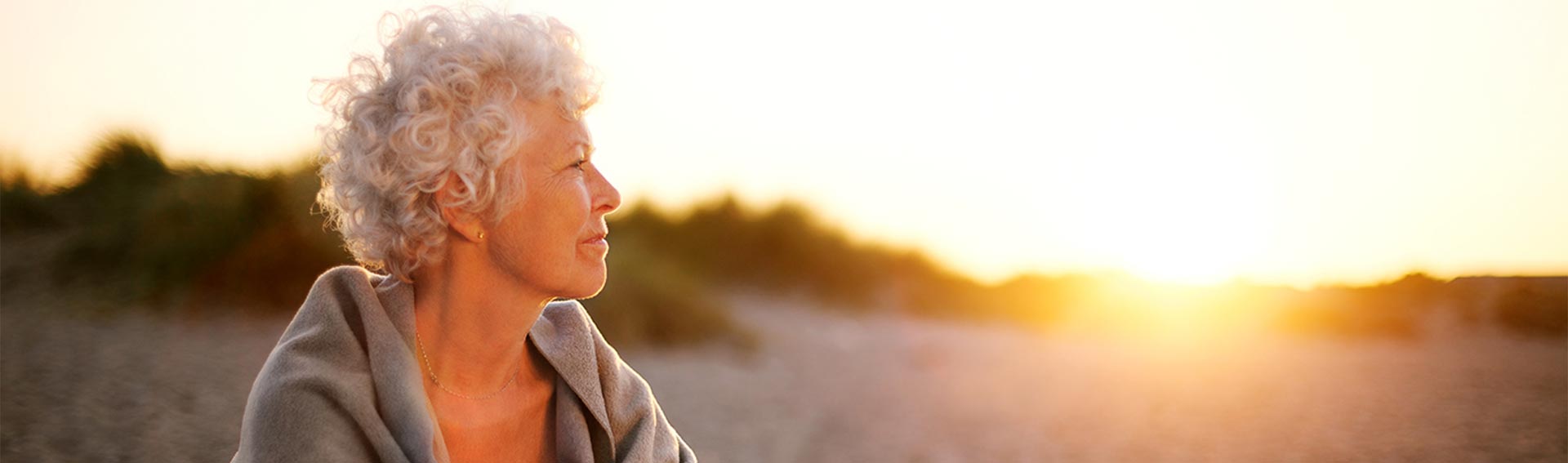 Woman relaxing on a beach during sunrise.