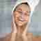 An excited woman happily applying Pevonia products during her get-ready routine.