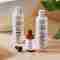 Hair Energize products, covered in water drops, sitting atop a counter next to leaves.