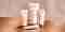 Pevonia's ProCorrective products alongside one another on a reflective brown table, in front of a beige backdrop.
